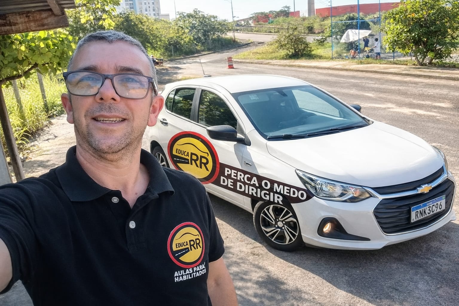 Instrutor Robson Ricardo ao lado do veículo de aulas